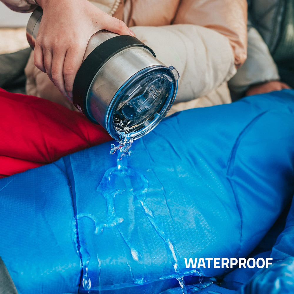 Person pouring water from a thermos onto a blue waterproof surface