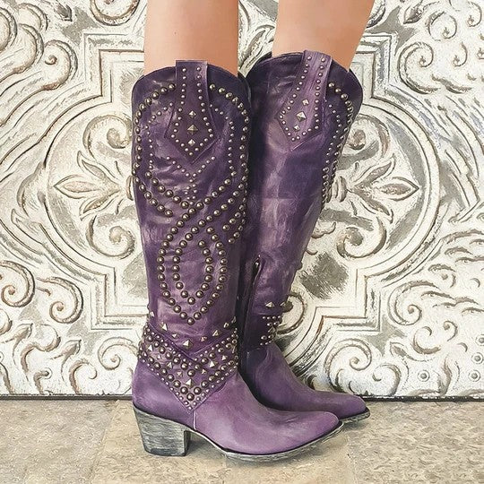 Purple studded boots on a decorative metal surface