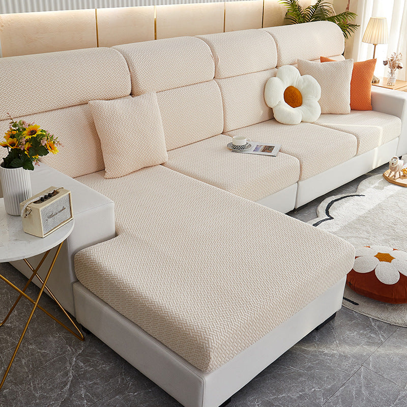 Beige sectional sofa in a living room setting with decorative pillows and a small table.