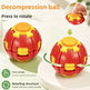 A red and yellow decompression ball toy shown on a light background with text and arrows explaining how to press and rotate it. A small inset at the top right shows a hand pressing the top of the ball.