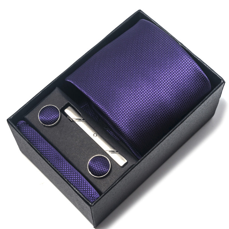 Purple tie set with tie, pocket square, and cufflinks in a black box on a white background