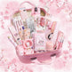 Pink stationery set with various items in a suitcase-like container on a white background