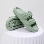 Pair of light green sandals on a white surface with a light gray background