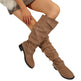 Brown knee-high boots worn by a person on a white background