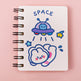 Notebook with space-themed illustrations on a pink background