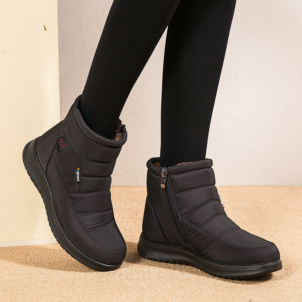 Black winter boots worn with black leggings on a neutral background