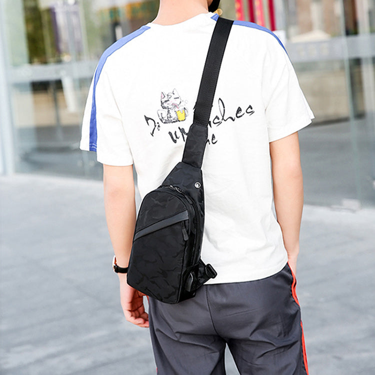 Person wearing a black crossbody bag with a blurred background