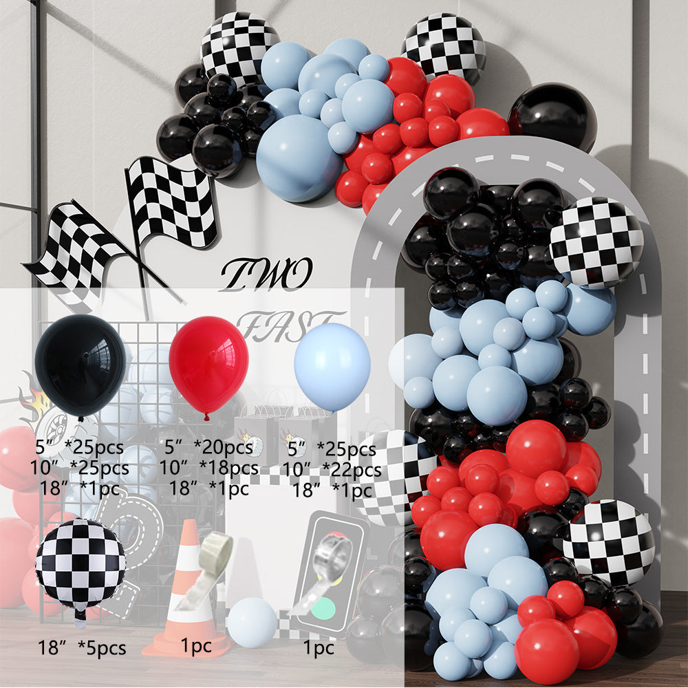 Balloon arch with red, blue, and black balloons, checkered flags, and race car elements.