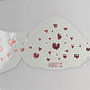 Decorative heart-patterned wings with 'KG012' on a gray background