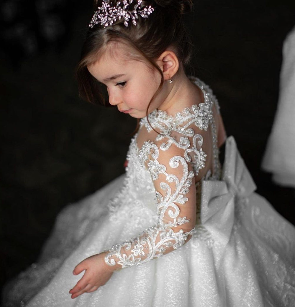 Young girl in a white lace dress with a dark background