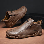 Brown leather shoes with zipper on a wooden surface