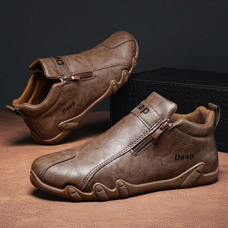 Brown leather shoes with zipper on a wooden surface