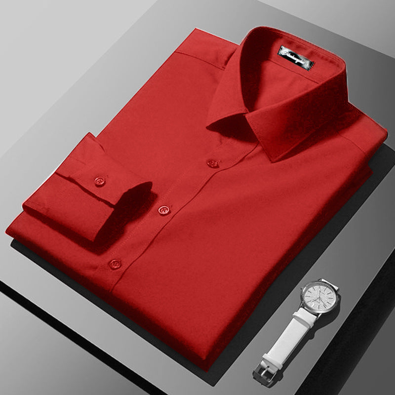Folded red shirt on a gray surface with a white watch.