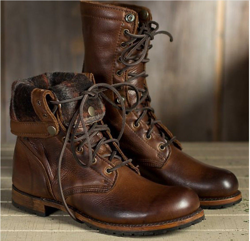 Pair of brown leather boots with lace-up design on a wooden surface.