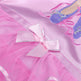 Close-up of a pink ballet outfit with a bow and shoes on a matching pink background