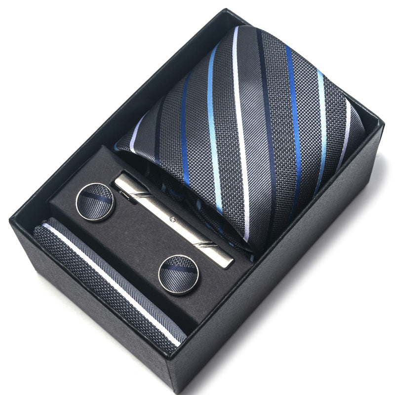 Tie, cufflinks, and tie clip set in a black box on a white background