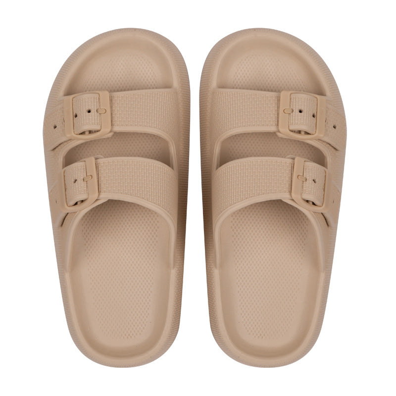 Pair of beige sandals with buckle straps on a white background