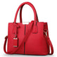 Red handbag with a strap on a white background