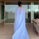 Person wearing a light blue saree in a modern living room.