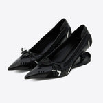Black pointed-toe shoes with bow details on a white background