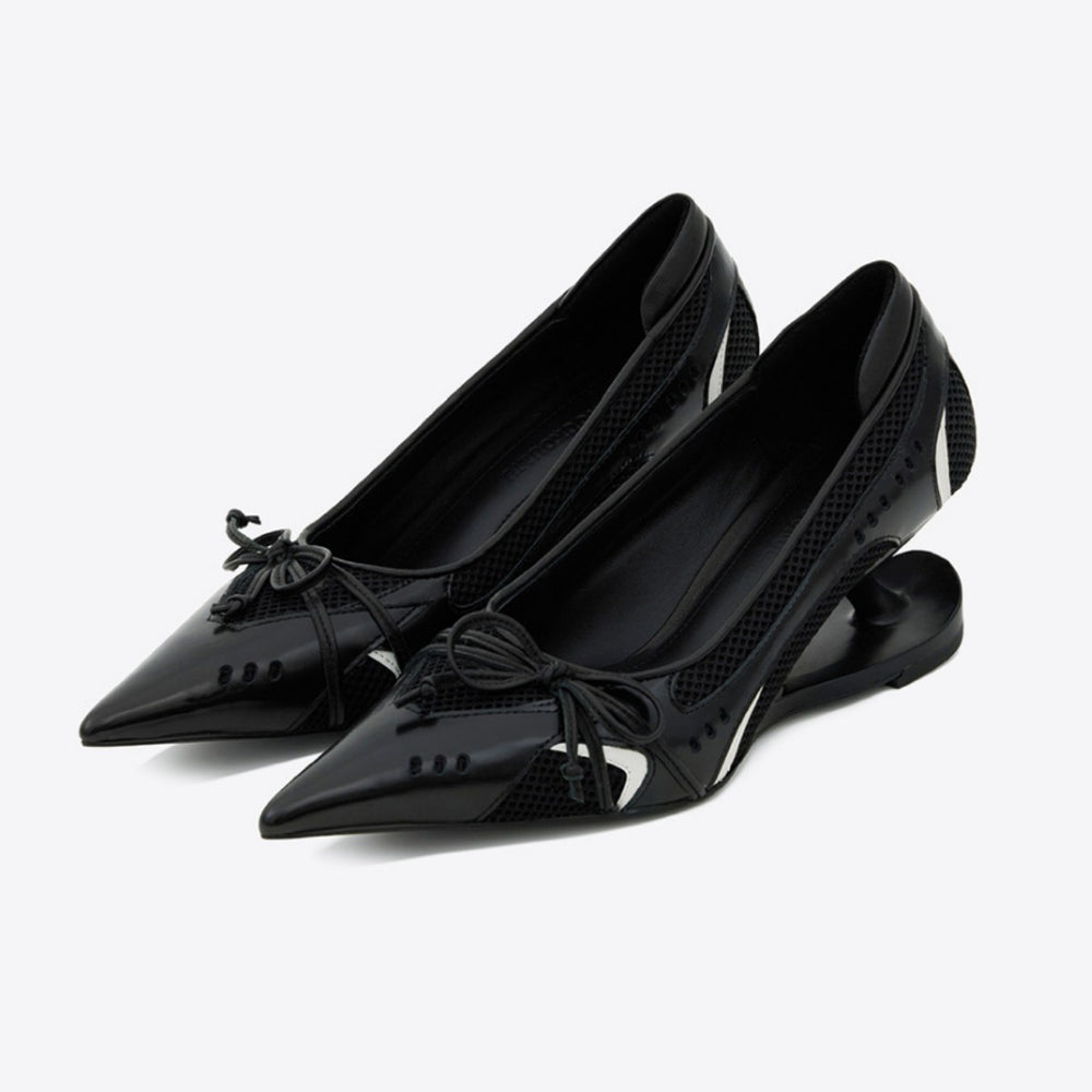 Black pointed-toe shoes with bow details on a white background