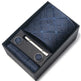 Blue patterned tie set with tie clip and pen in a black box on a white background