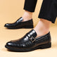 Black leather shoes with a crocodile texture and gold buckle on a beige background