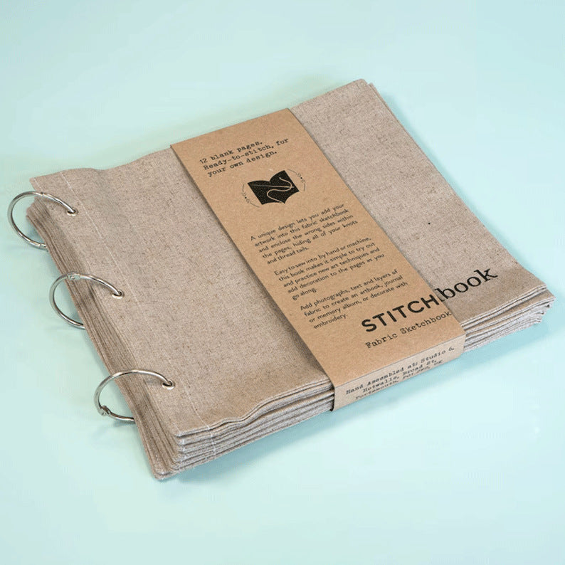 Fabric sketchbook with 'STITCHbook' branding on a light blue background