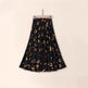 Black skirt with gold animal print on a beige background