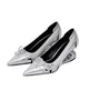 A pair of metallic silver pointed-toe pumps with low block heels, decorative bow details on the toes, and a glossy black interior, shown against a plain white background.