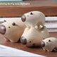 Three small wooden pig figurines in different sizes arranged on a wooden surface, with stacked books in the background and the text 'Entering the Pig Gate, Amitabha' at the top.