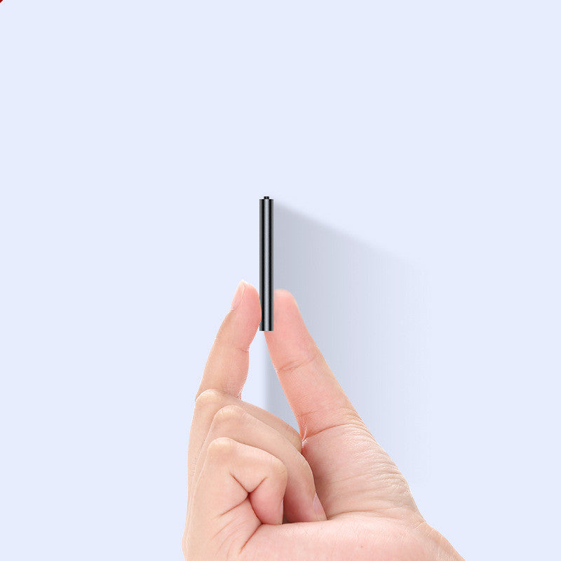 Hand holding a thin black object against a light gray background