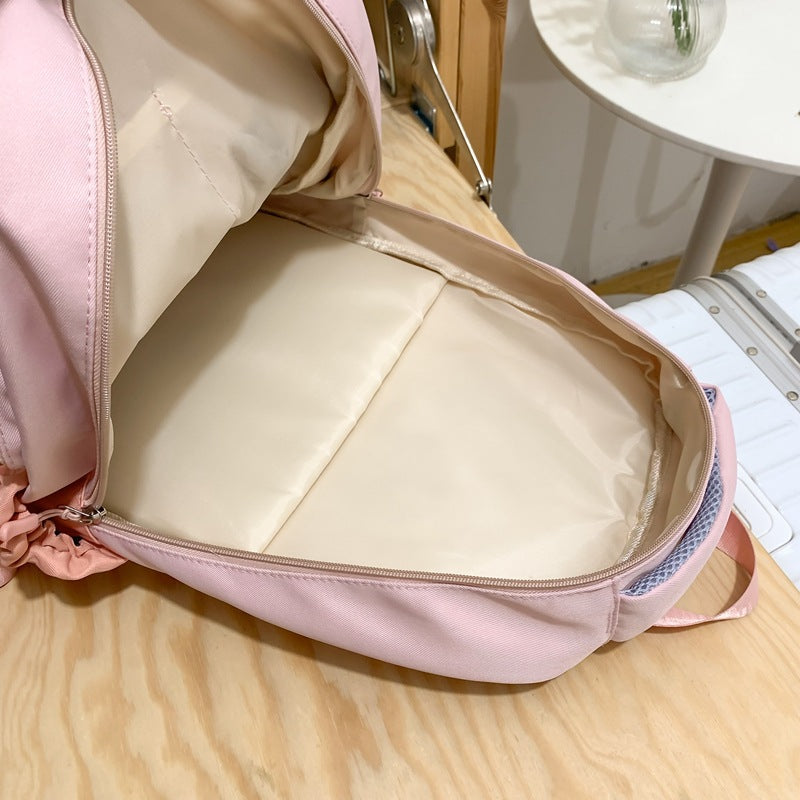 Pink backpack with open lid on a wooden surface