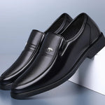 Pair of black leather loafers on a light blue background