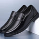 Pair of black leather loafers on a light blue background