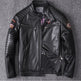 Black leather jacket with patches on a gray background
