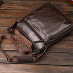 Brown leather bag with visible brand name on a wooden surface