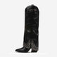 A single black leather knee-high boot with pointed toes, low block heels, and silver rhinestone embellishments along the lower shaft and around the buckle detail near the top, shown against a plain white background.