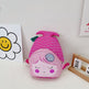 Pink mermaid-shaped bag with a face on a white surface