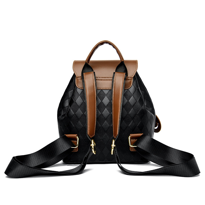 Black quilted backpack with brown accents on a white background