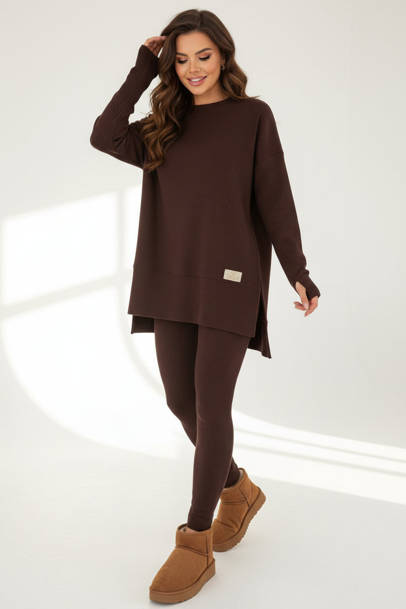 Woman wearing a maroon outfit with beige boots in an indoor setting.