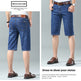 A composite catalog image showing men's denim shorts from two angles: a back view on the left and a front view on the right. The shorts are a medium blue wash with a brown leather belt.
