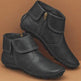 Pair of black leather boots with zippers on a brown background
