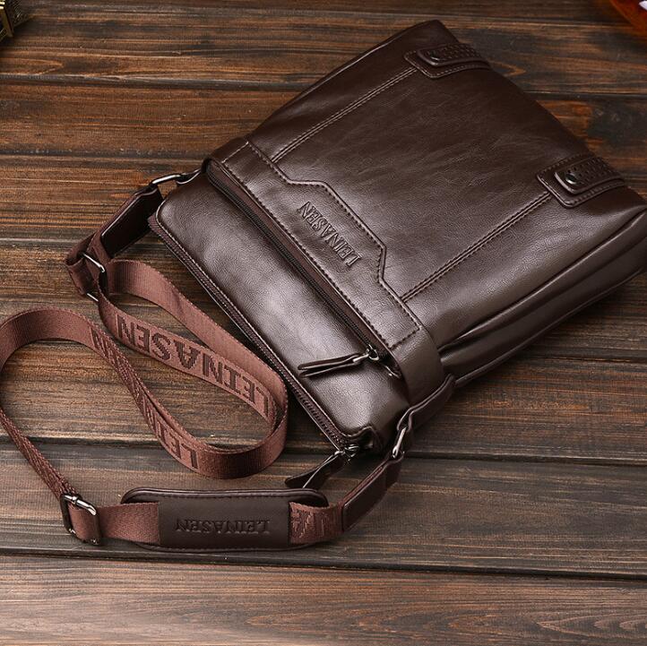 Brown leather bag with strap on a wooden surface