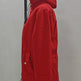 A bright red hooded puffer jacket displayed on a black clothing hanger against a plain light gray wall.