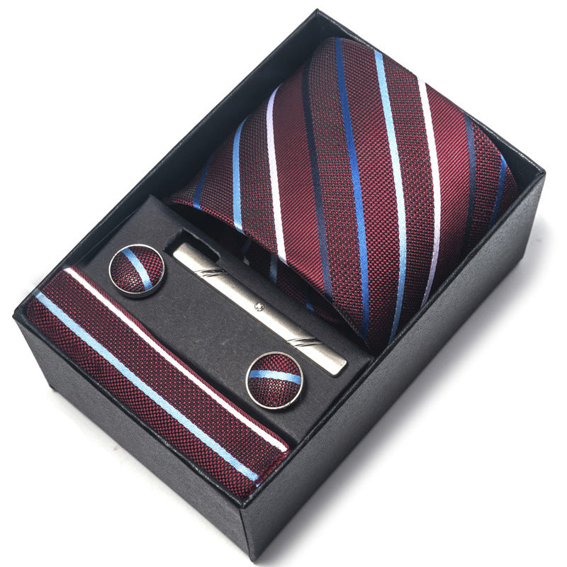 Striped tie, tie clip, and cufflinks set in a black box on a white background