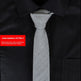 Gray tie on a black shirt with a red item number label.