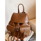 Brown leather backpack on a light surface with a neutral background