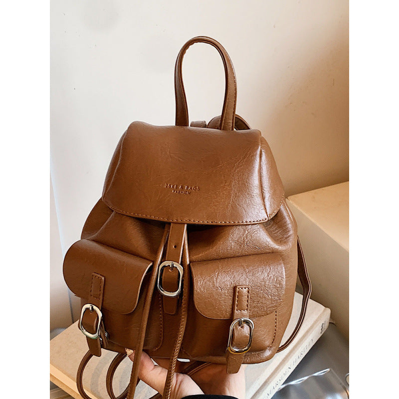 Brown leather backpack on a light surface with a neutral background