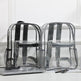 Two clear backpacks with black straps on a white surface.
